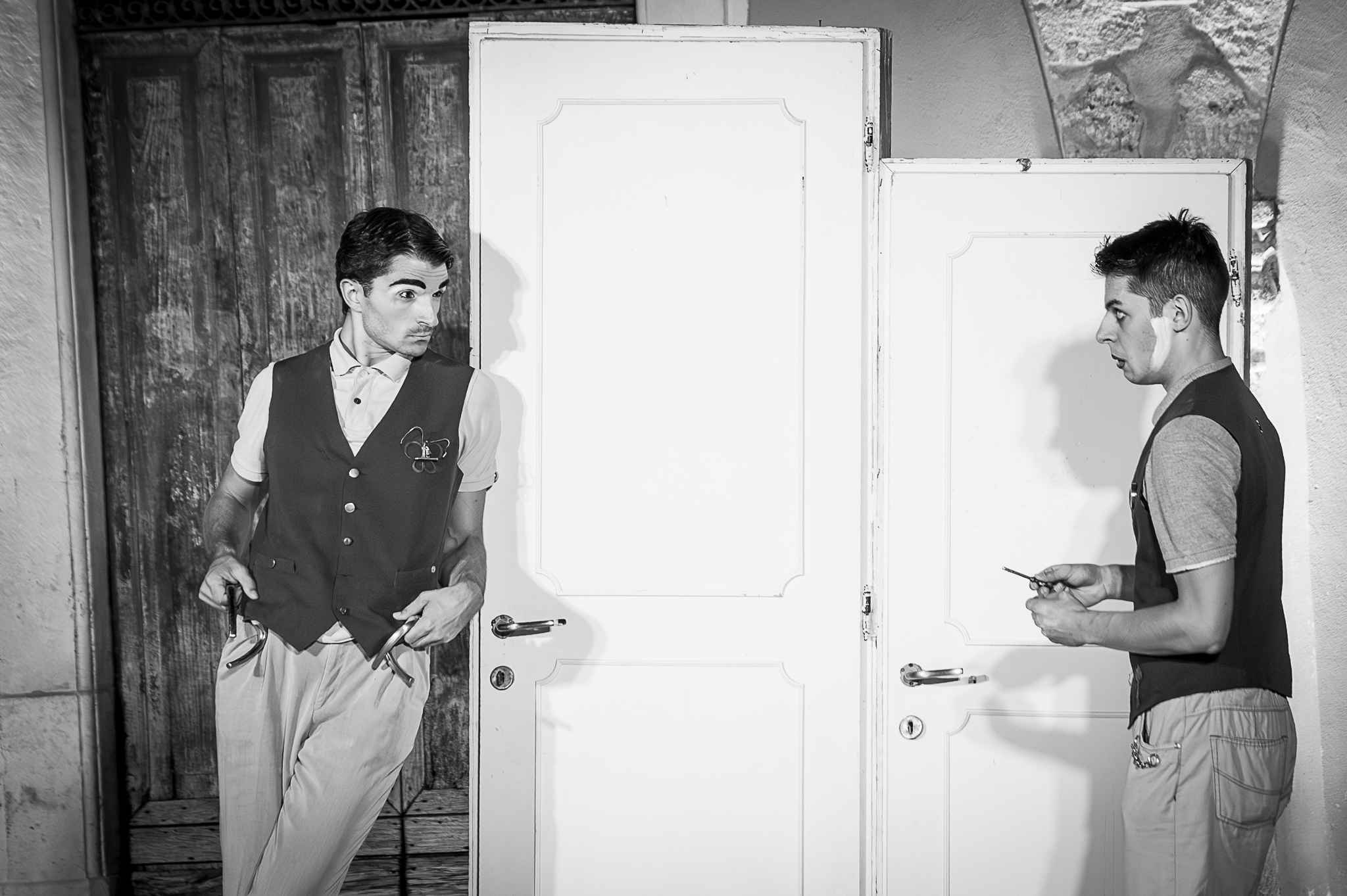Due clown si guardano davanti a due porte bianche.