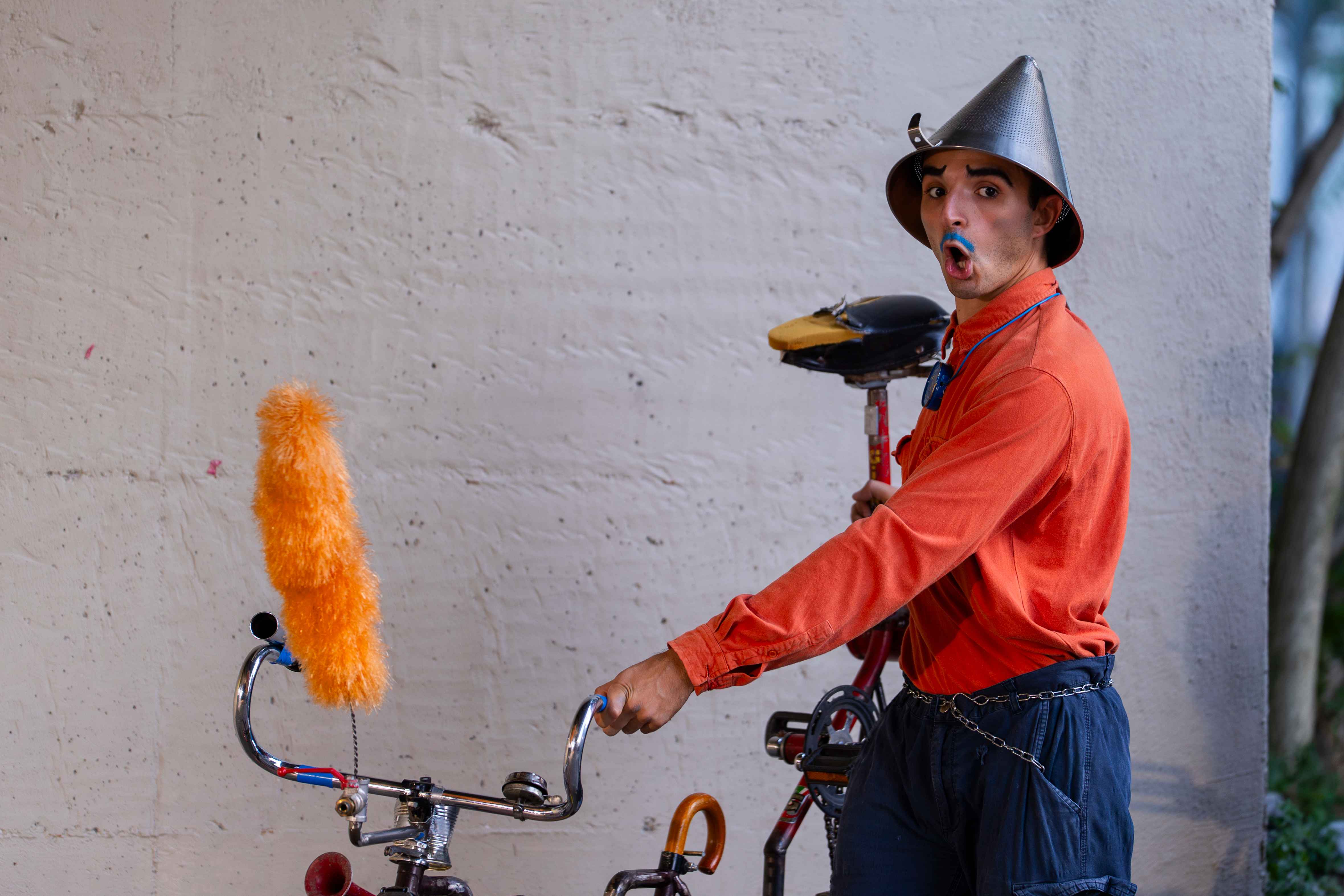 A clown brings a strange bicycle on stage.