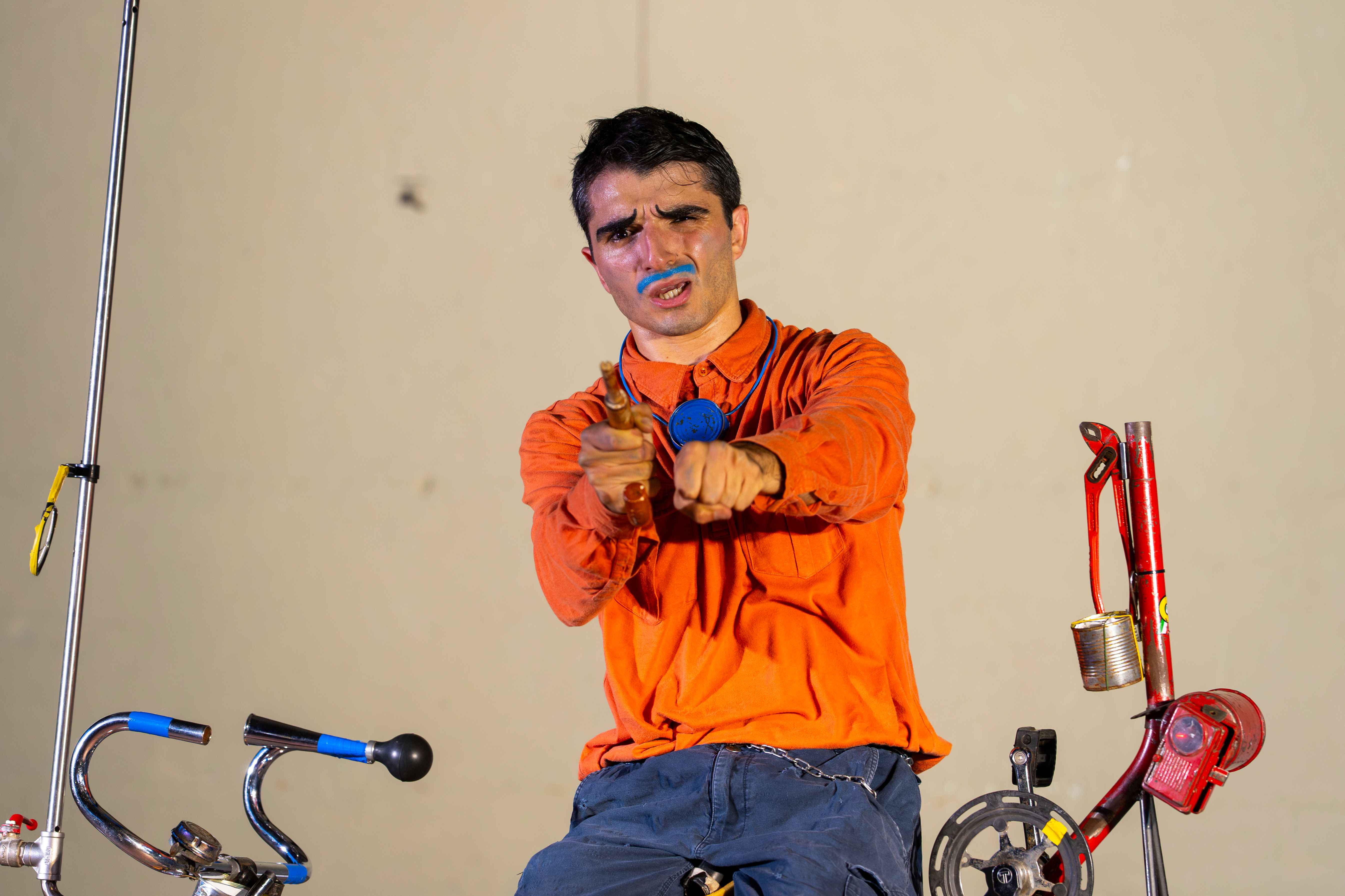 A clown sitting on a bike.