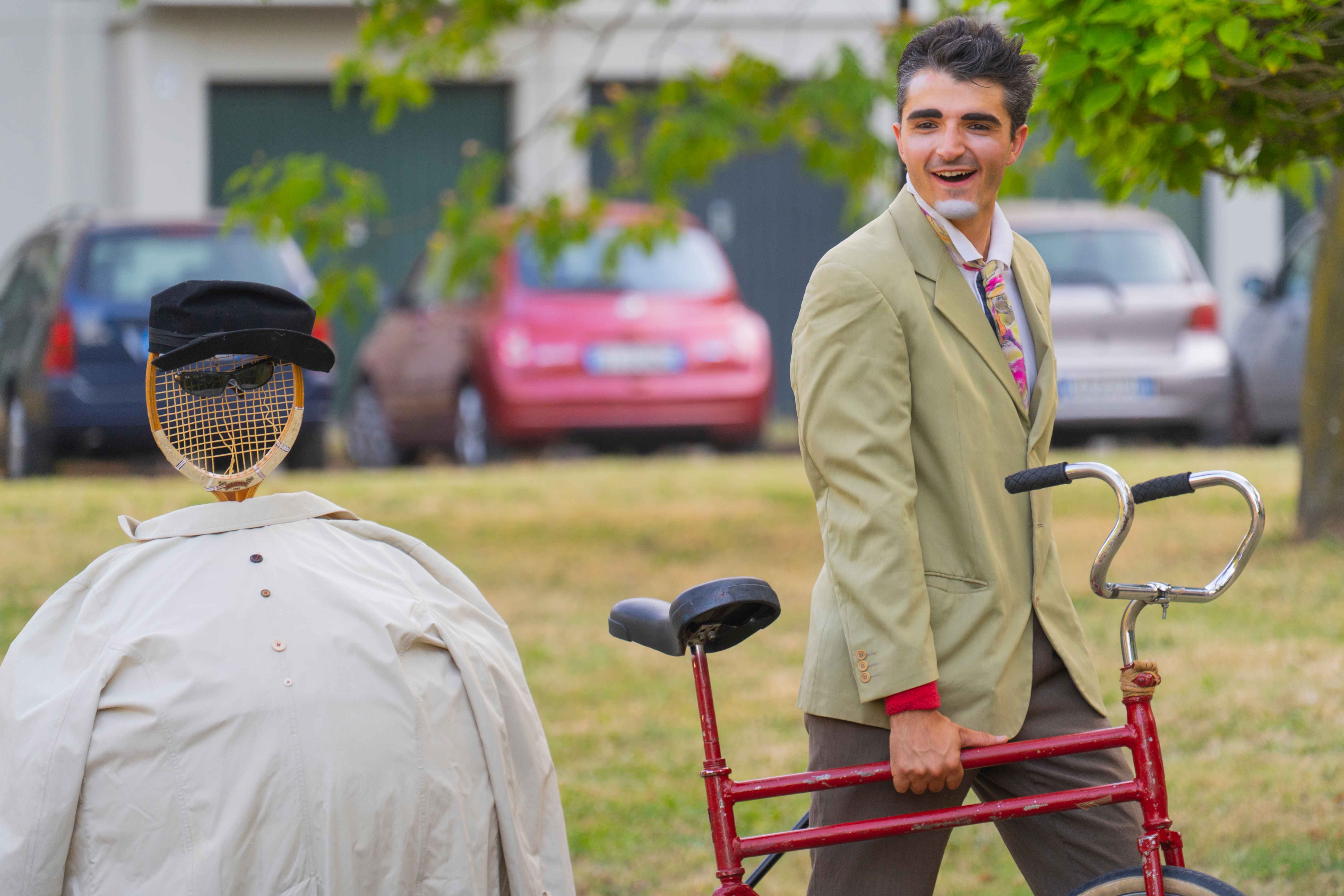Un clown con una bici rossa.
