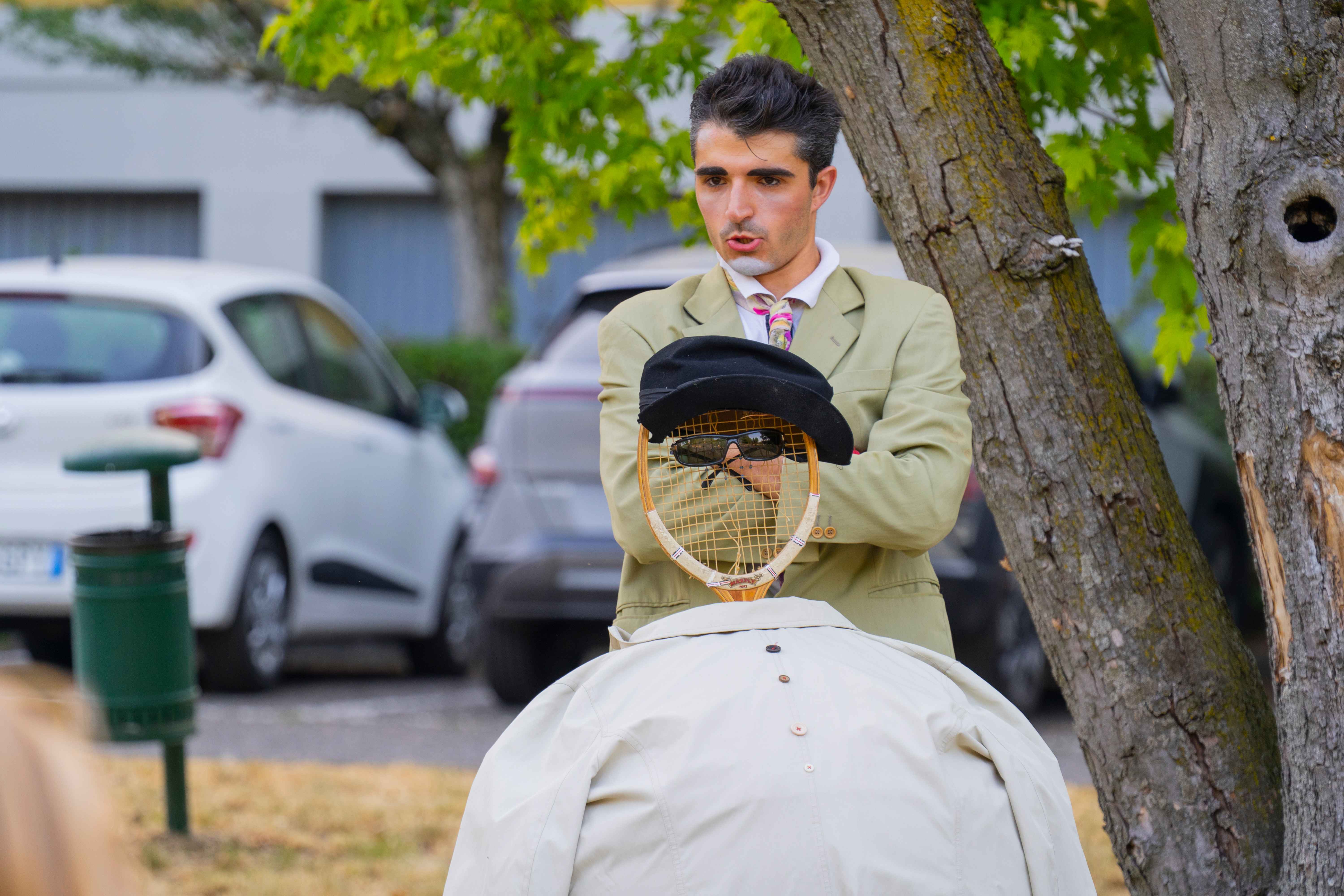 Un clown costruisce un personaggio con una racchetta da tennis.