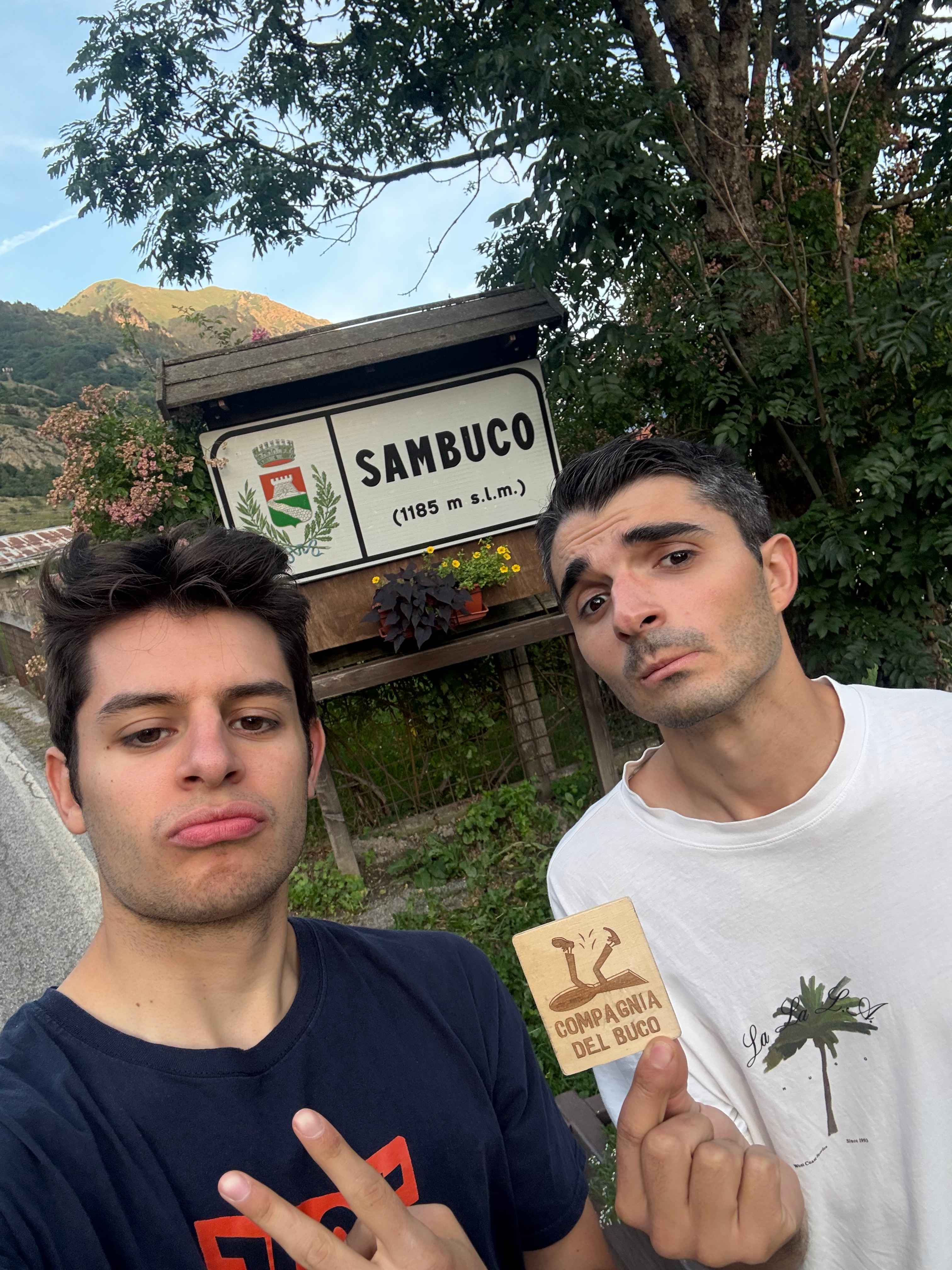 Compagnia del Buco in front of the Sambuco village sign