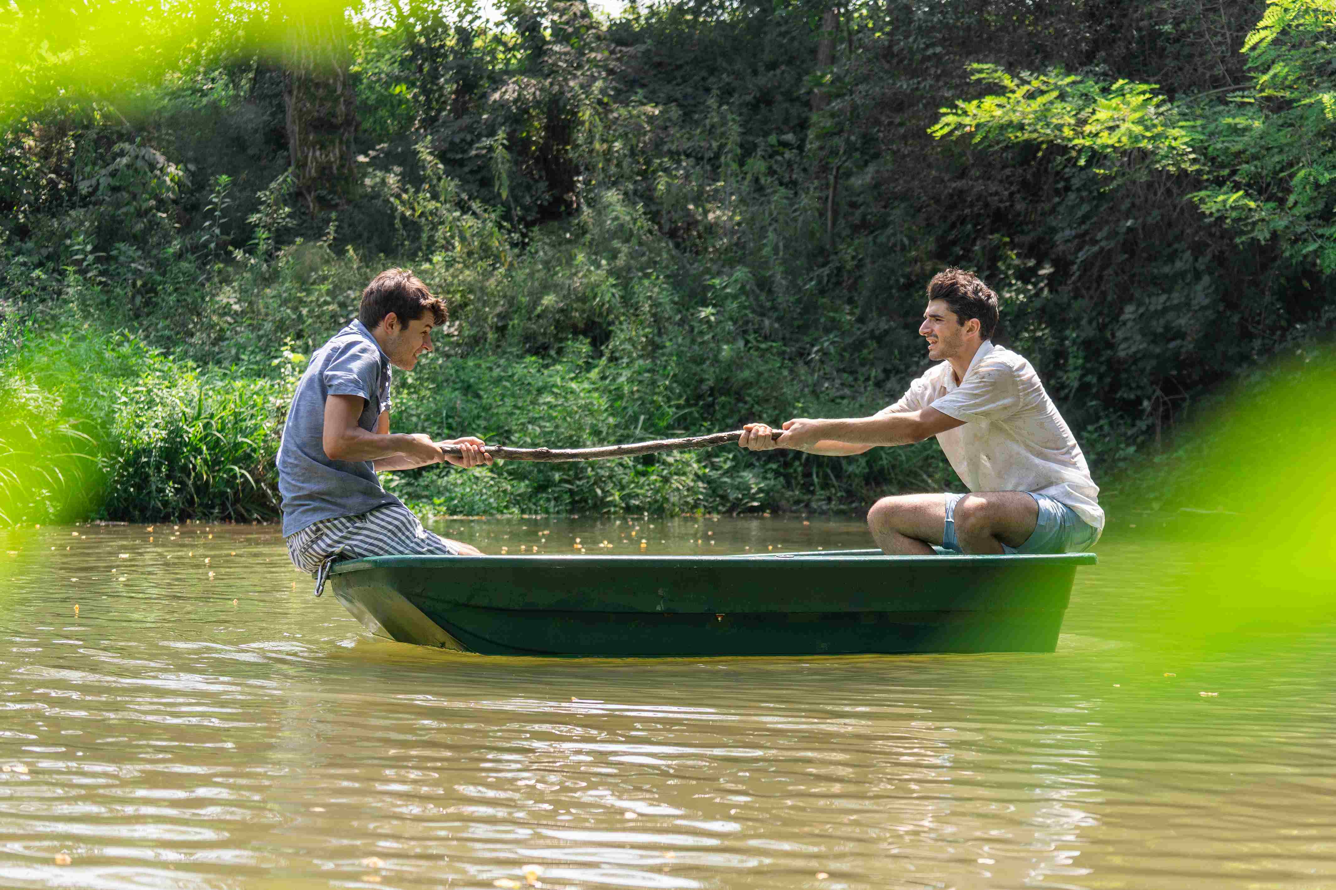 Two characters compete for a stick on a small boat in the middle of the water.